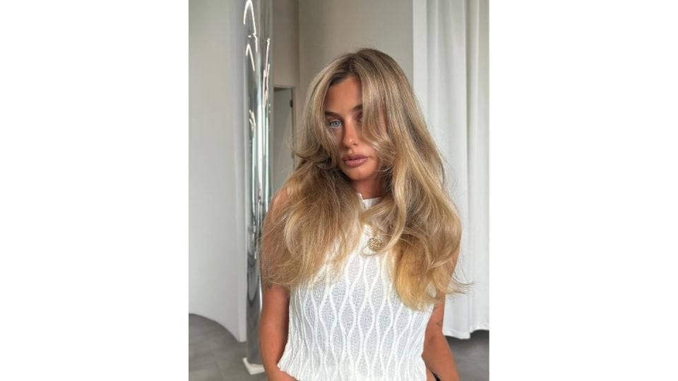 An Instagram post from L’Oreal Professionnel depicting a woman with blue eyes and a sandy blonde hair colour