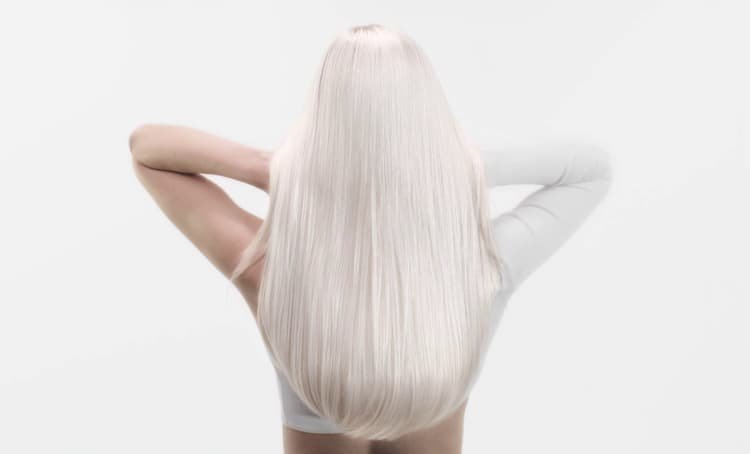 Woman with long white hair, illustrating anti-breakage methods suitable for healthier, stronger-looking hair