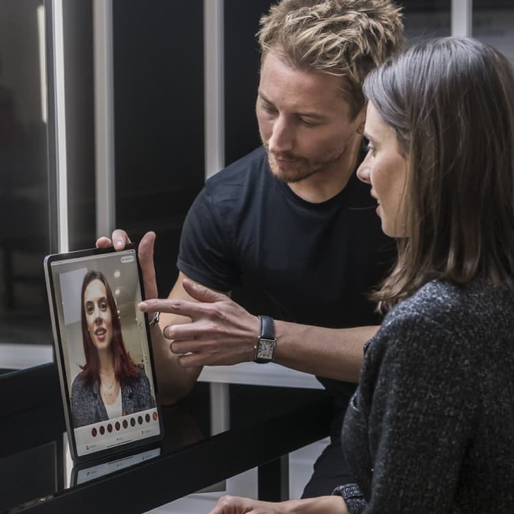 A woman and hairstylist using the My Hair [iD] color app for a personalized color experience, the first pro tool to complement salon services