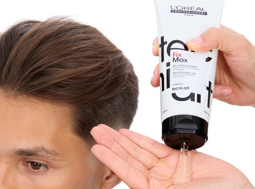 Focus on a man’s hair being styled by a professional stylist using hair shaping gel, following the latest hairstyle trend